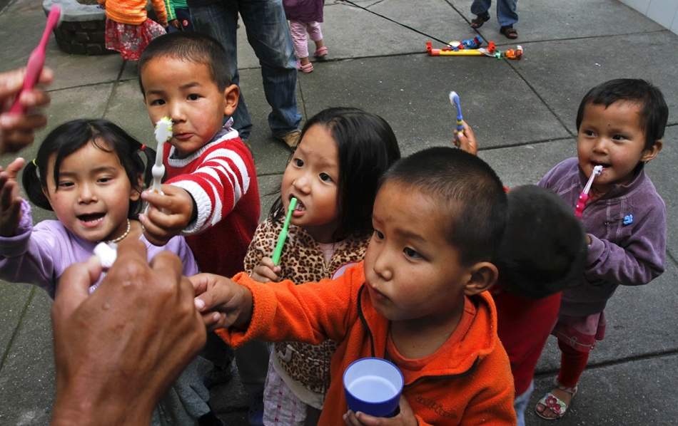 Indiába szállított tibeti menekültek gyerekei várnak a fogkrémre június 19-én, a Menekültek Világnapján.