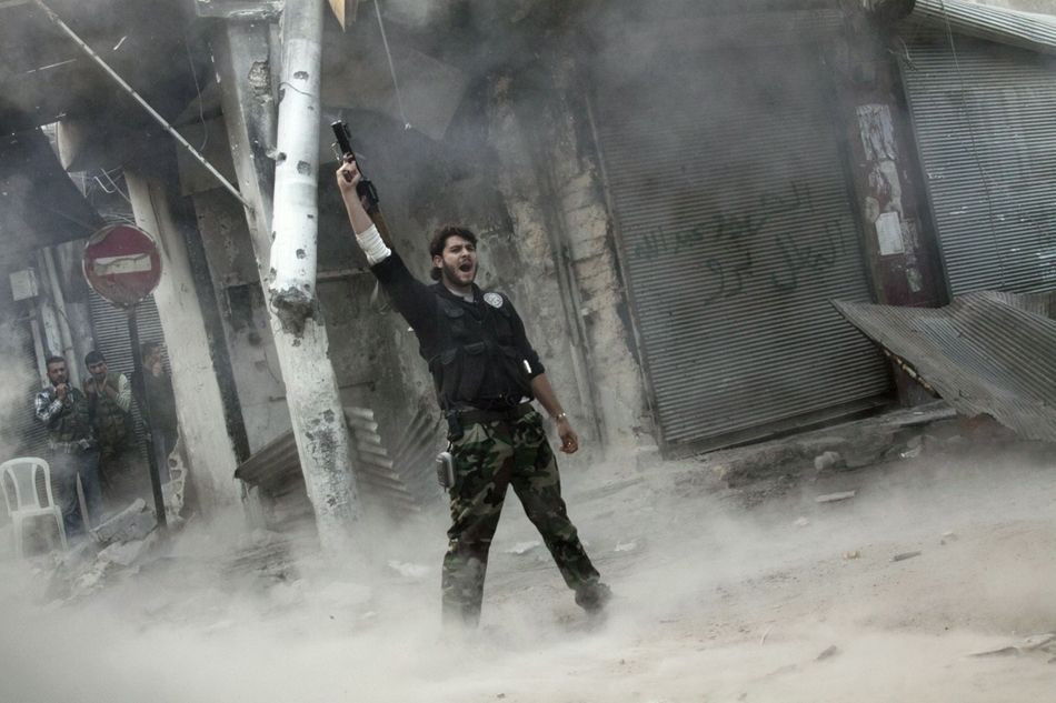 Szíriai lázadó vállról indítható rakétát lőtt ki egy épületre a kormányerők elleni harcban Aleppóban.